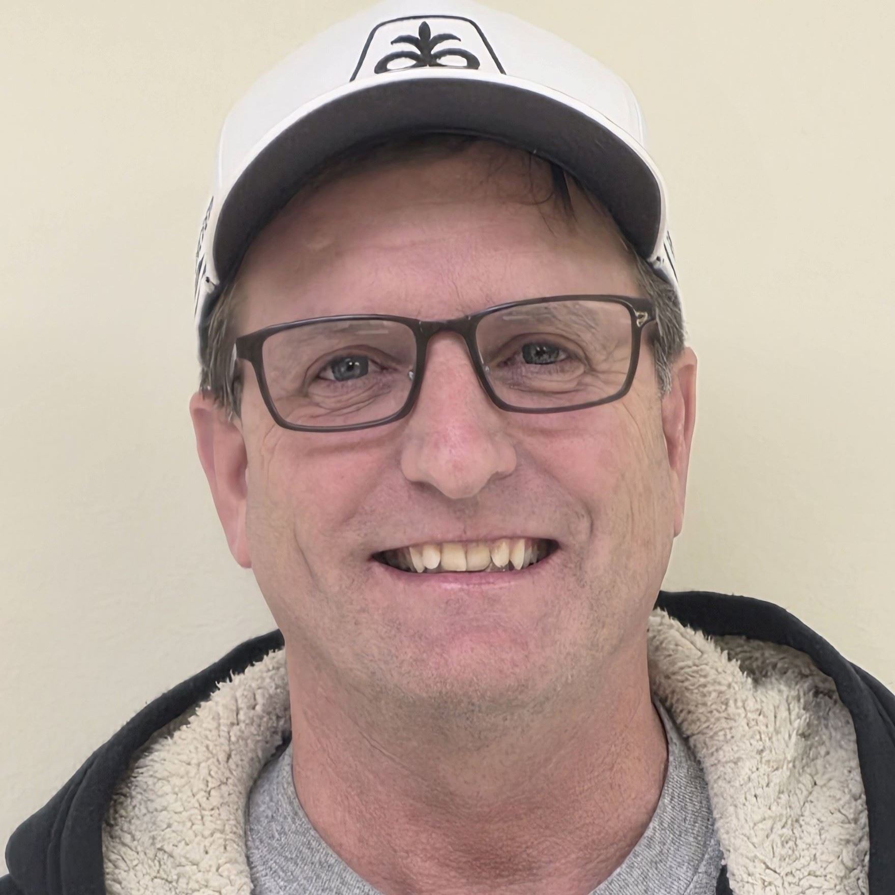 man wearing hat and glasses smiling